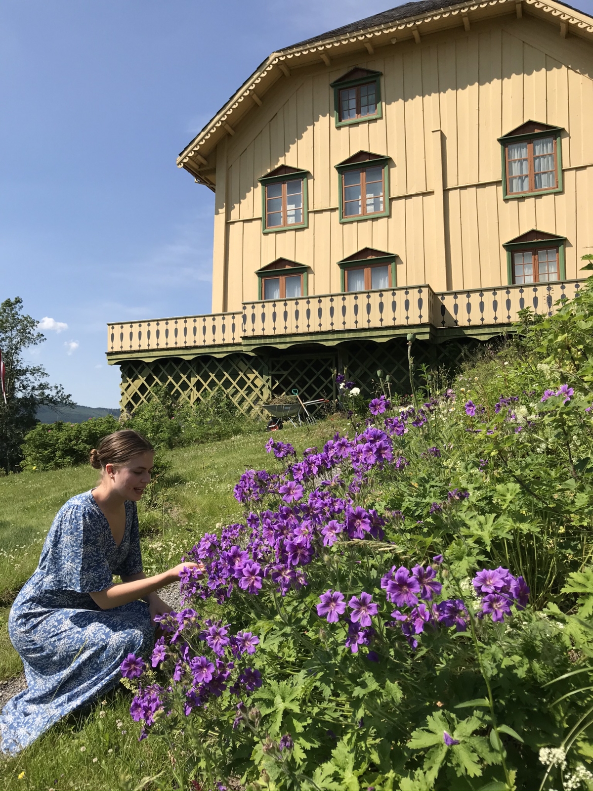 Dame som ser på blomstene i hagen til Bjørnstjerne Bjørnson.